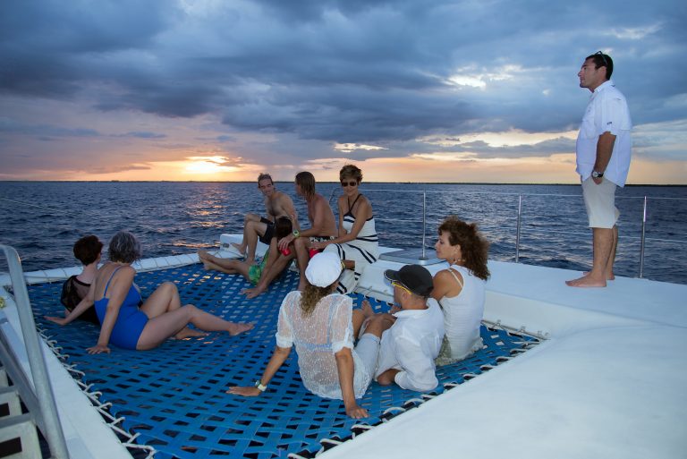people on catamaran net during sunset boat charters riviera maya catamarans