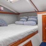 comfortable bed with blue cushions in yoya catamaran, riviera maya, mexico