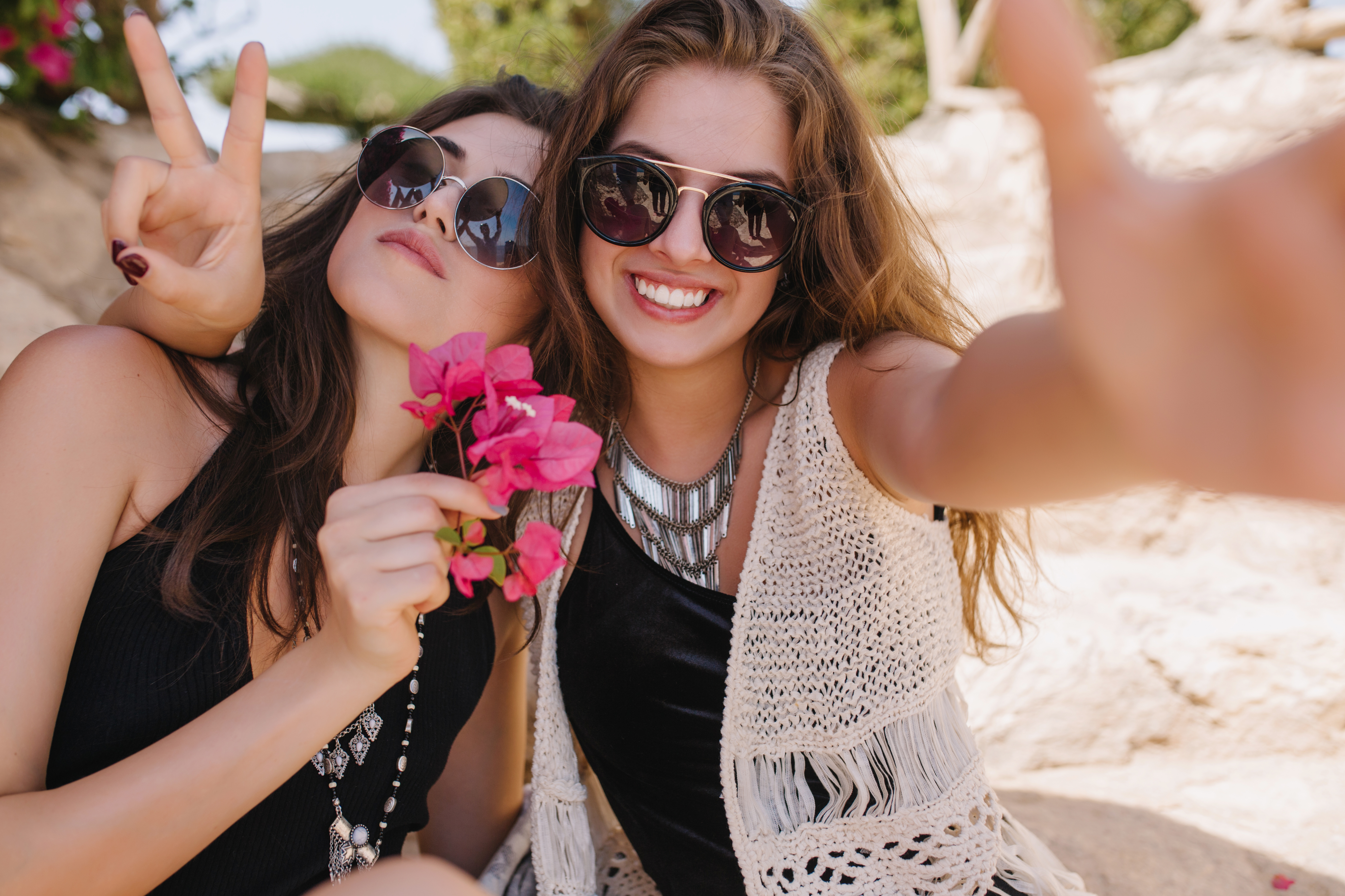 Joyful attractive friends having fun together and making selfie on summer resort. Fascinating girl in knitted retro attire relaxing with sister and laughing, spending time outside. Joyful attractive friends having fun together and making selfie on summer resort. Fascinating girl in knitted retro attire relaxing with sister and laughing, spending time outside