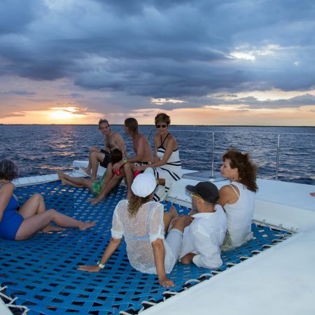 people on catamaran net during a sunset tour riviera maya catamarans