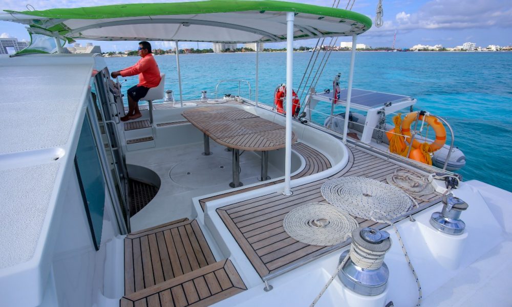 Captain driving a catamaran rental cancun isla mujeres tour