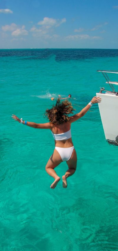 woman jumping off catamaran cancun isla mujeres riviera maya catamarans 1
